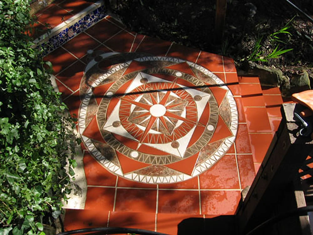 Tribal Mandala: a terracotta, cream and bronze tile mosaic compass star set into a garden stair landing